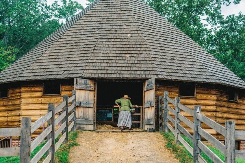 Dressed in period clothing, a guide opens Washington's 16-sided treading barn to visitors.
