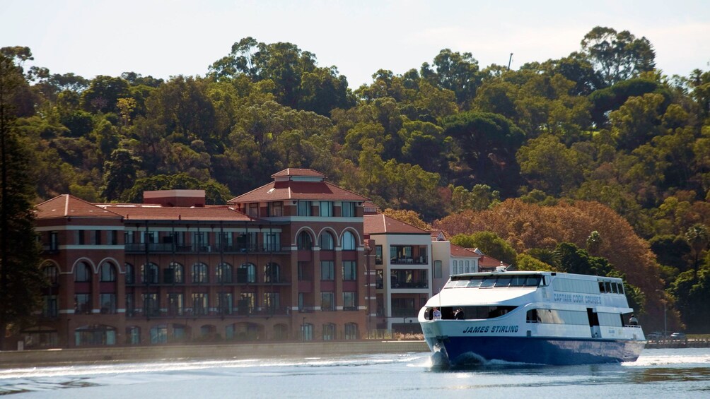 a cruise ship sailing past a mansion on the swan river