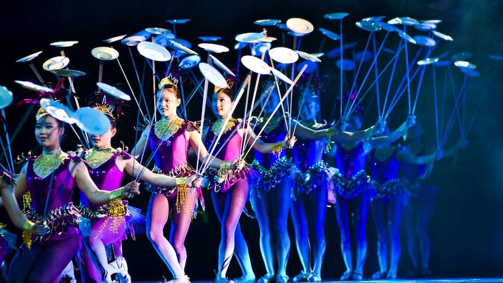 A row of female performers spinning china plates at the Award-winning Shanghai Acrobatics Show in Shanghai