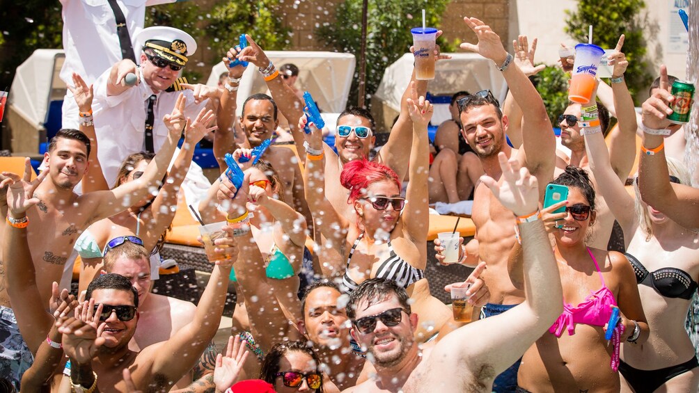 Guests at the Las Vegas pool party raising their drinks in the air