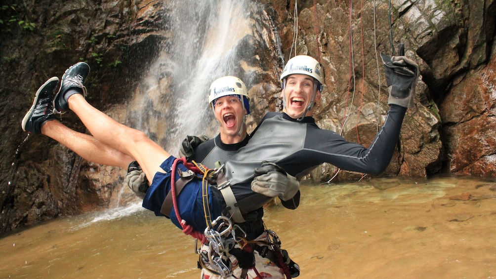 Friends celebrate a successful repel down a majestic waterfall near Boca de Tomatlan and Puerto Vallarta