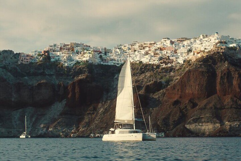 Catamaran Sailing At Santorini's Caldera