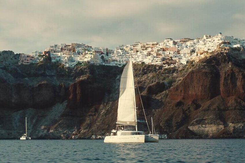 Catamaran Sailing At Santorini's Caldera