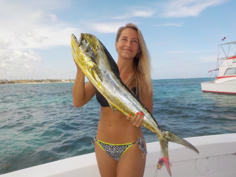Woman holds large fish on fishing boat in Punta Cana