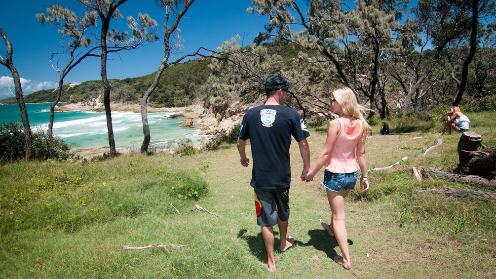 Young couple holding hands on sunny beach in Brisbane