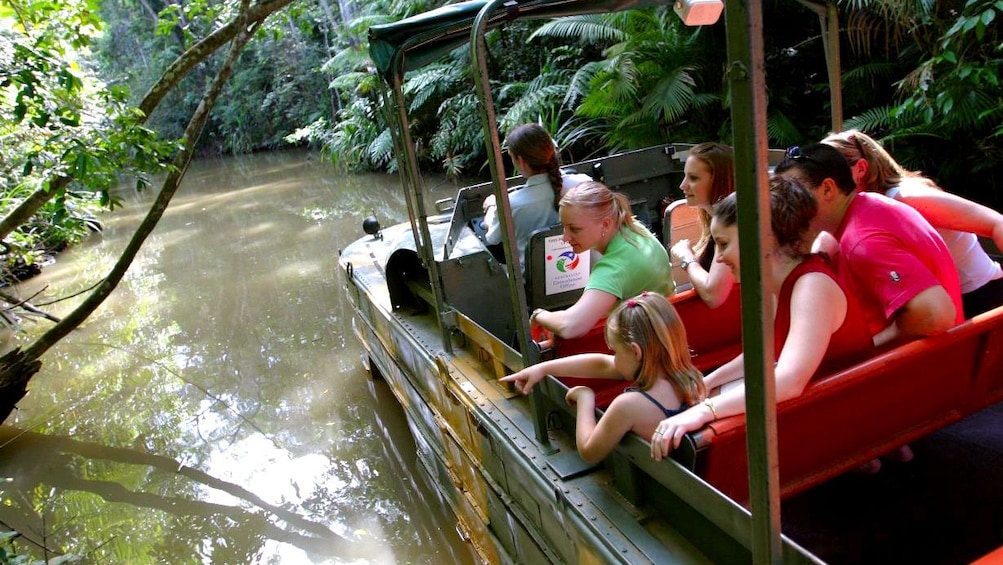 group of people enjoying ride on amphibious DUKW through river in Cairns