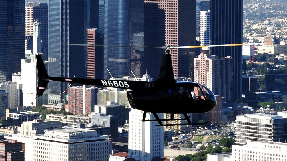 helicopter flying through the city during daytime in Los Angeles
