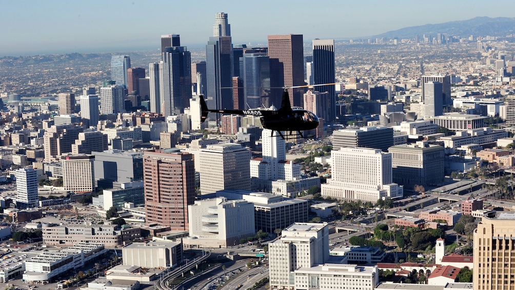 Black helicopter flying above the city of Los Angeles during the daytime