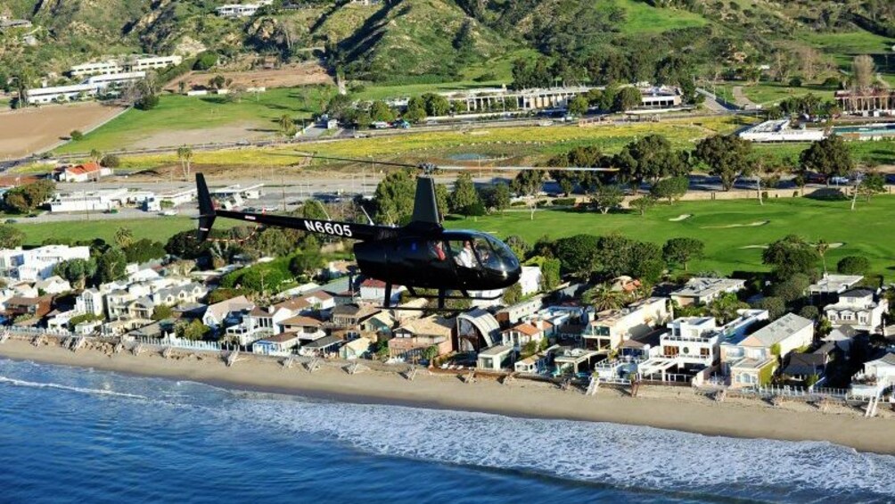 helicopter soaring along the beach in Los Angeles