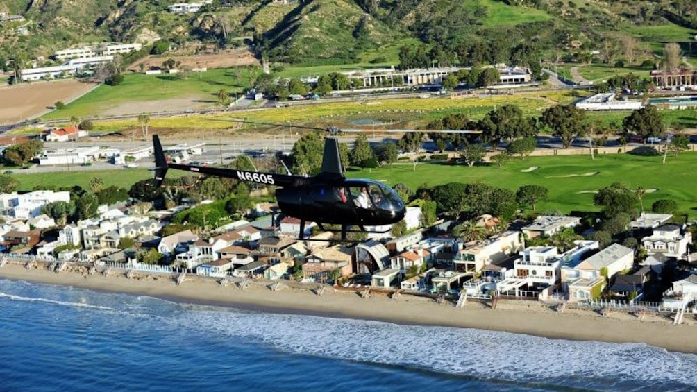 helicopter soaring along the beach in Los Angeles