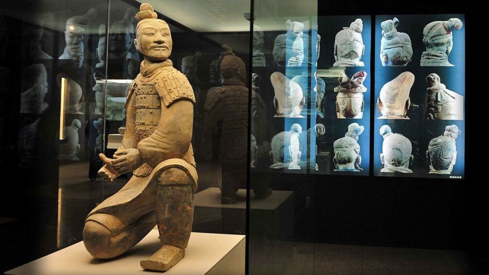 a preserved Terry Cotta warrior statue behind glass in Xi'an