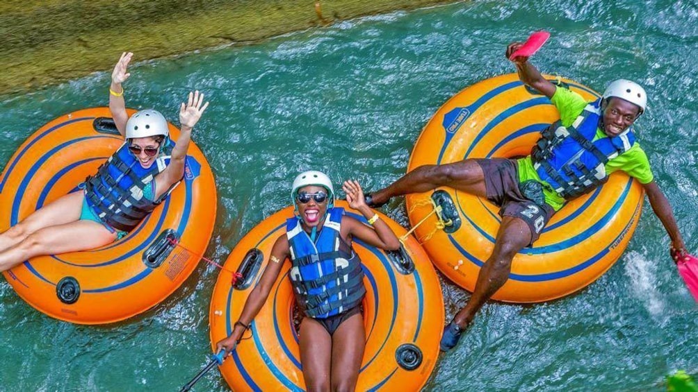 Three people on inner tubes floating