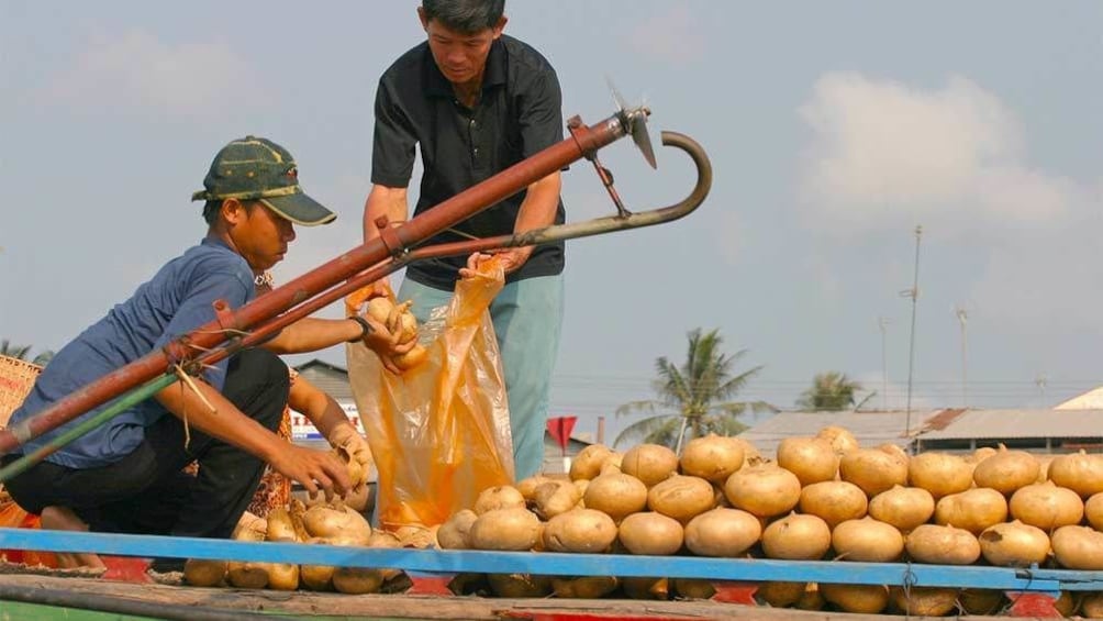 Locals transporting goods via the Mekong River in Vietnam
