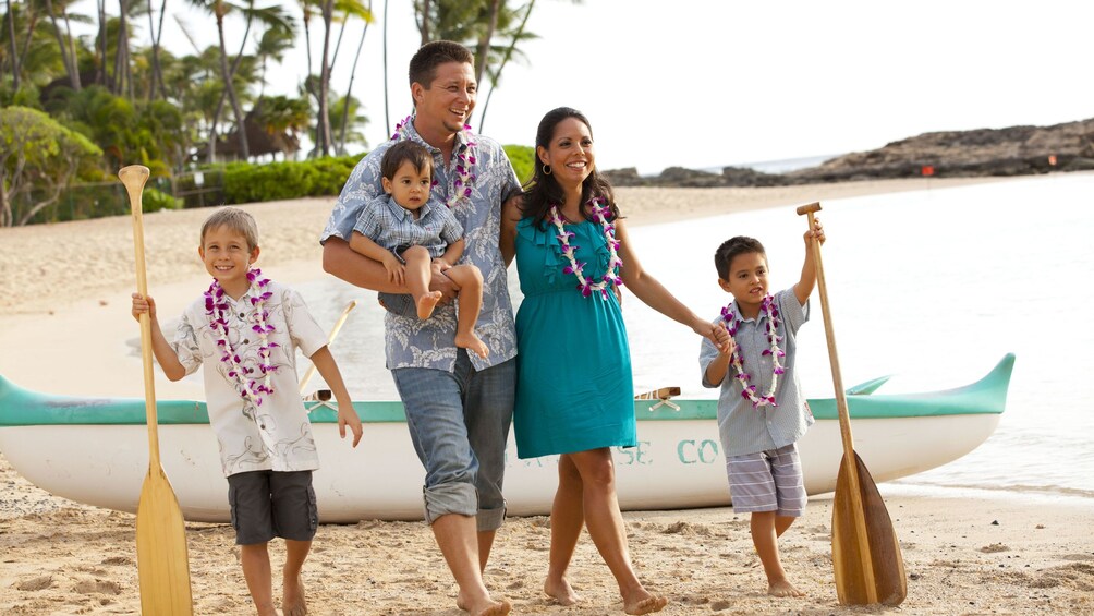 Family wearing leis on the beach in Oahu