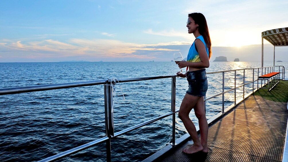 woman with a glass of wine in the sunset in Thailand