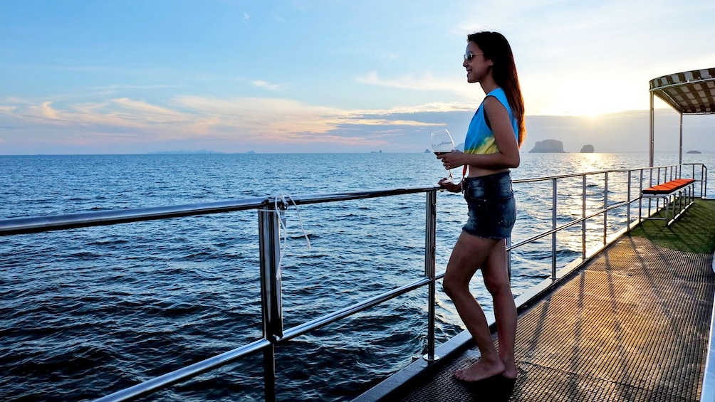 woman with a glass of wine in the sunset in Thailand
