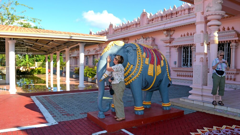 woman engaging an elephant sculpture in Trinidad and Tobago