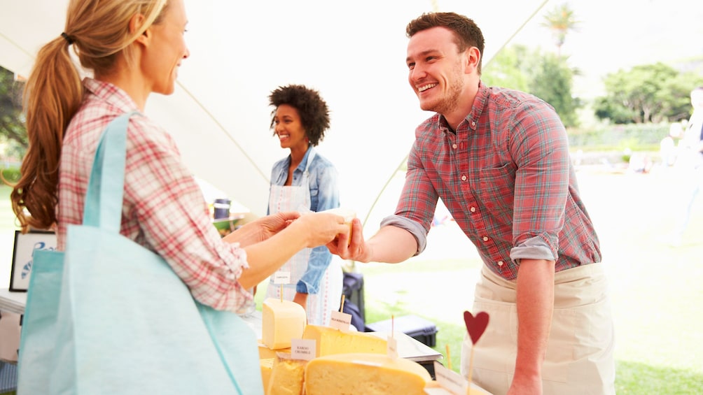 Man giving cheese to a woman