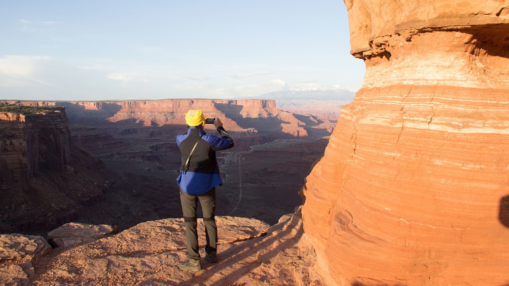 Hiker taking a photo of Canyonlands National Park in Utah