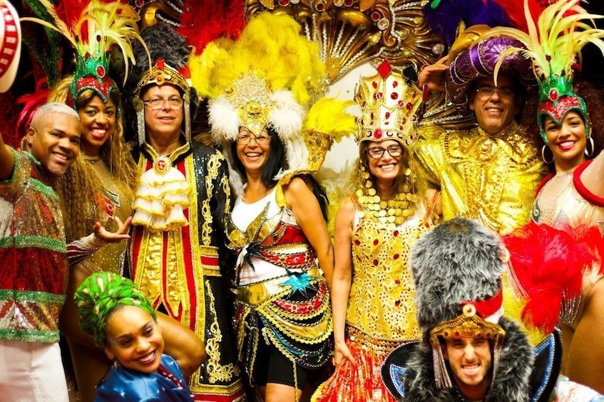 Group of tourists pose in elaborate Carnaval costumes and headpieces