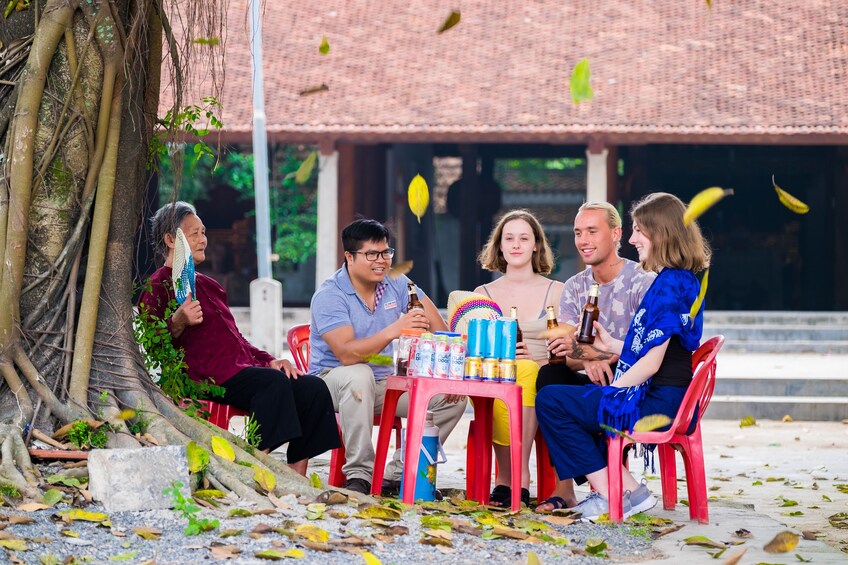 Tourists enjoy drinks at red plastic table and chairs in Vietnam