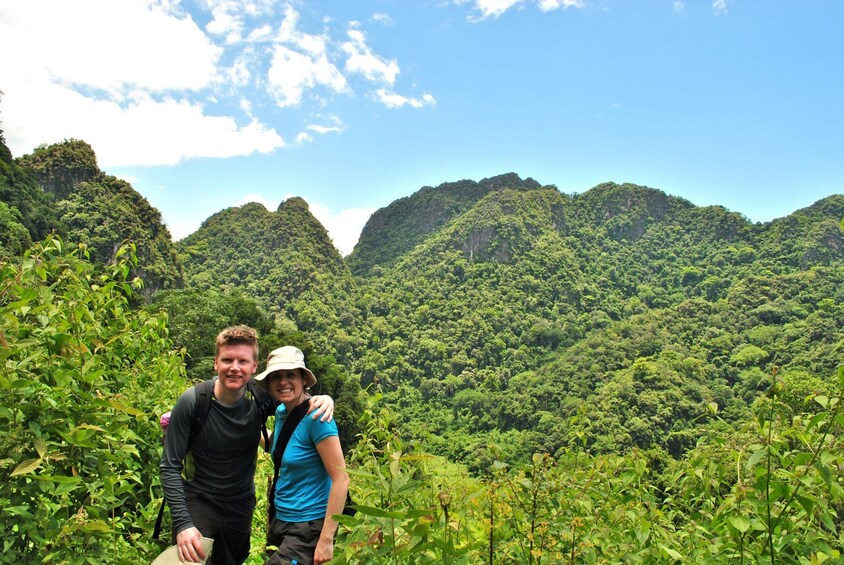 Couple stop on their hiking tour for a photo in the lush jungle of Luang Prabang