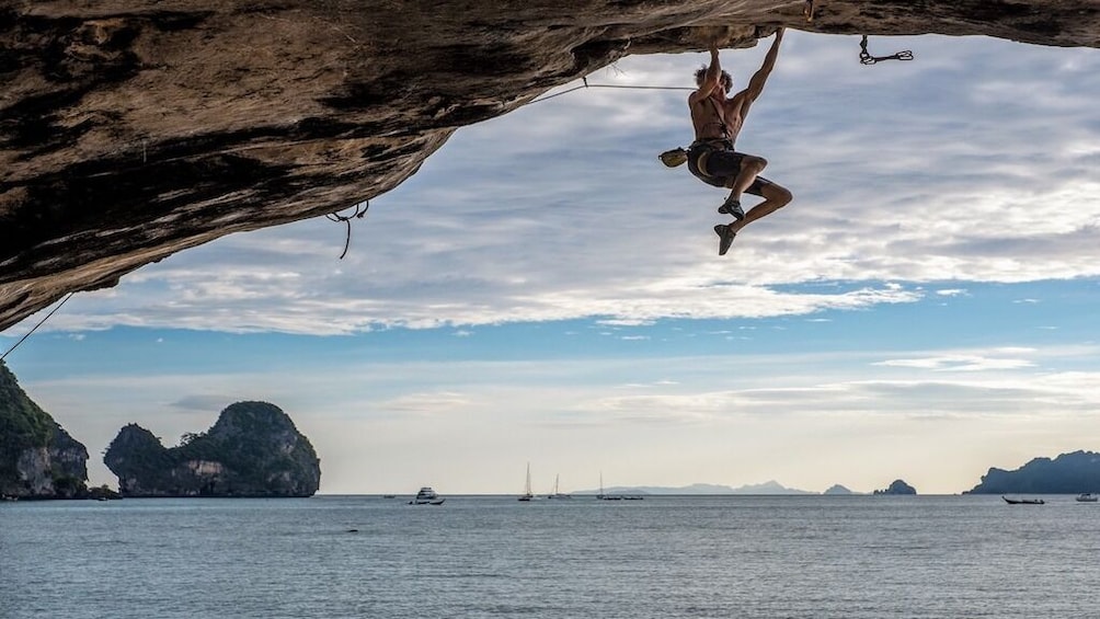 Man hangs off of rock face in Krabi, Thailand