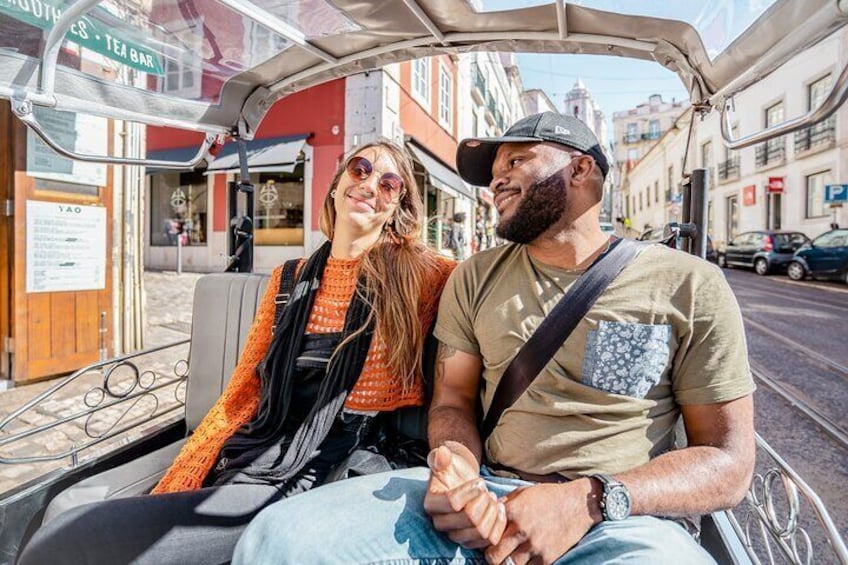 Tourists enjoying a tuk tuk guided tour in Lisbon
