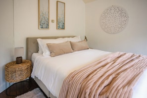 Dreamy bed with soft blush tones.