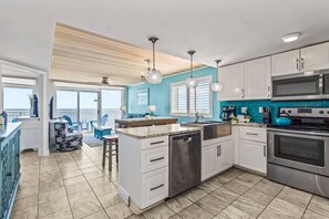 Cook, dine, and relax in this stunning open-concept space featuring a modern kitchen with granite countertops, stainless steel appliances, and vibrant coastal accents. The dining area flows seamlessly to the living room, all with gorgeous ocean views