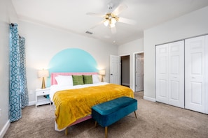 King bed with plush white beddings, plush end stool, and classic nightstands