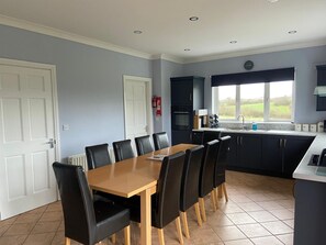 Ballygarrett Holiday Home, County Wexford. Open plan dining area with large table. Modern kitchen. 