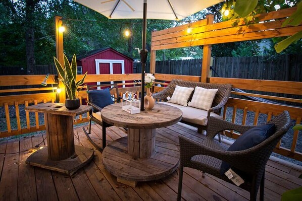 Exterior deck with hanging lights right in front of entrance.
