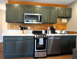 Well stocked kitchen with dishes, stove/oven, dishwasher