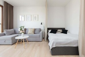 A comfortable sleeping space with a bed, white and black bedding, and a simple yet elegant design.