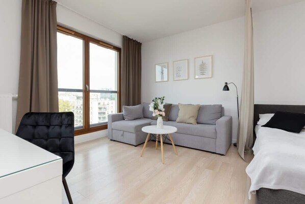 A modern living space with a light gray sofa, a small white coffee table, and a cozy atmosphere.