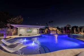 Enjoy the hot tub and resort-style pool, illuminated at night.