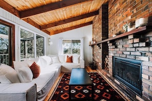 Ilkley House - Cosy up by the fireplace in the living room, surrounded by nature's beauty.