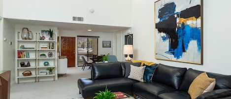 Bright and open living room looking toward the dining area and front entry.