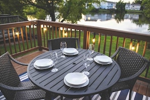 Lakeside Lookout back deck with table, four chairs and ambient lighting!