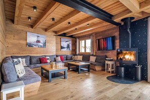Bask in alpine elegance in our expansive living area, featuring a plush sofa, a crackling fireplace, and a TV that's perfect for evening entertainment.