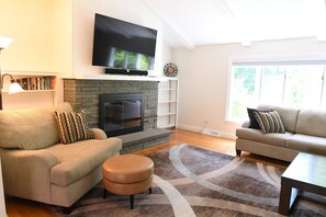 Living room with 65" smart TV, gas fireplace, and plenty of seating