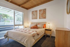 A beautifully styled second bedroom has a queen-sized bed, side tables and storage space for your belongings.
