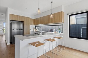 The gourmet kitchen is designed around a centrepiece island bench, where you can prepare meals, socialise or enjoy slow mornings at home.

