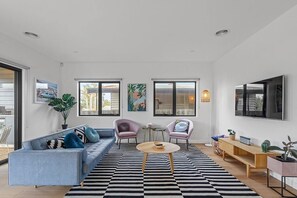 The open plan living and dining area flows to the patio, flooding the home with an abundance of light and natural breezes.