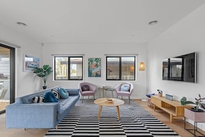 The open plan living and dining area flows to the patio, flooding the home with an abundance of light and natural breezes.