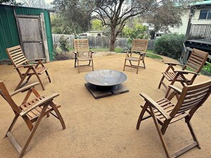 The raised section of the backyard, featuring a fire pit and chairs, provides the perfect setting for memorable get-togethers at home.
