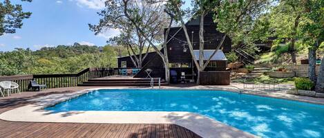 Pool and deck area overlooking a lush valley of Texas trees and native foliage