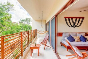 A private balcony through glass sliders with a hammock for the most sublime nap