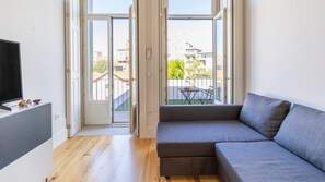 Bright living area with a sofa and a flat screen TV. #living #tv #airbnb